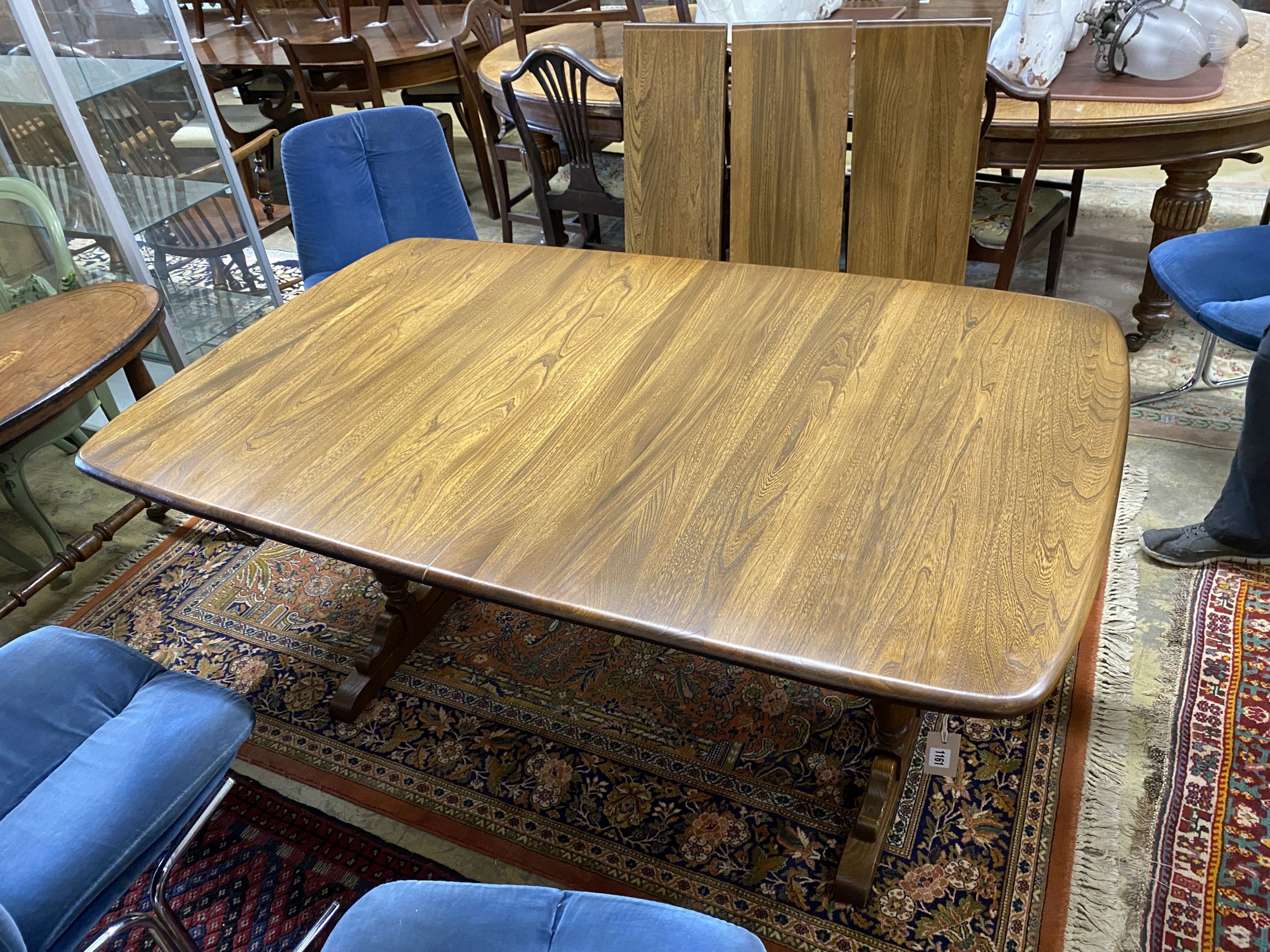 An Ercol Golden Dawn elm extending dining table, length 250cm extended (three spare leaves), width 100cm, height 74cm